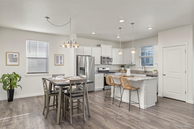 kitchen featuring white cabinets, a kitchen island, a healthy amount of sunlight, and appliances with stainless steel finishes