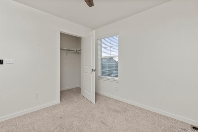 unfurnished bedroom featuring ceiling fan, a closet, and light carpet