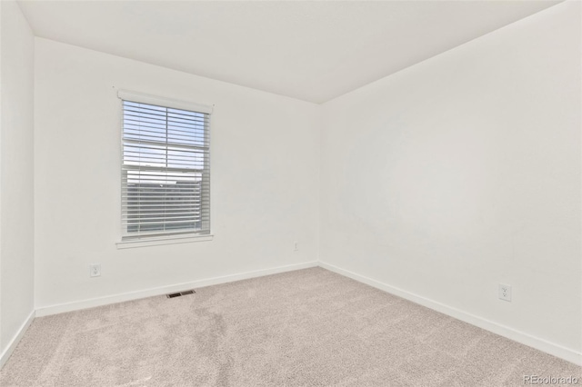 unfurnished room featuring light carpet