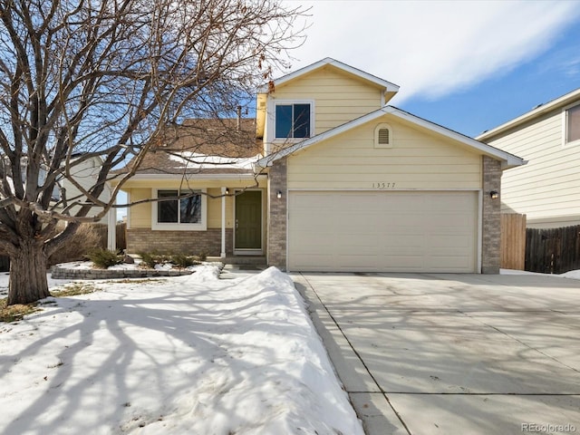 traditional-style home with an attached garage, fence, concrete driveway, and brick siding