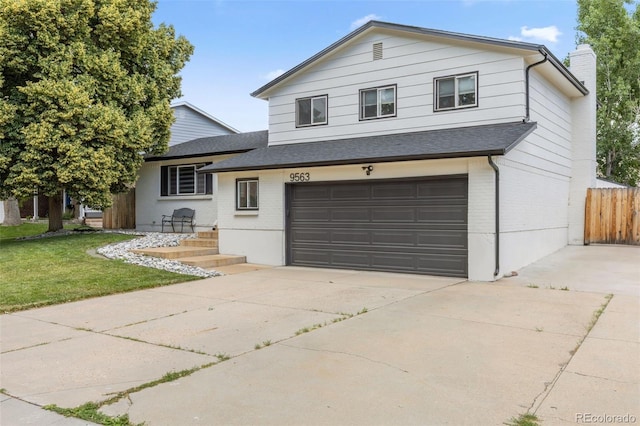 9563 W Caley Ave, Littleton, CO 80123 - split level home with an attached garage, brick siding, a chimney, a shingled roof, and concrete driveway
