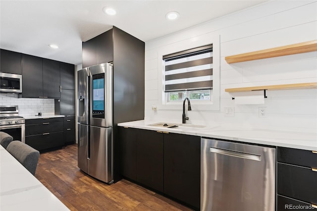 9563 W Caley Ave, Littleton, CO 80123 - kitchen featuring stainless steel appliances, dark cabinets, tasteful backsplash, dark wood finished floors, and recessed lighting