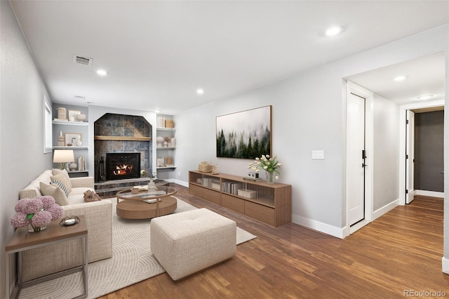 9563 W Caley Ave, Littleton, CO 80123 - living room featuring wood finished floors, a fireplace, recessed lighting, and built in shelves