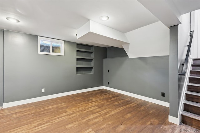 9563 W Caley Ave, Littleton, CO 80123 - below grade area featuring stairs, built in shelves, and wood finished floors