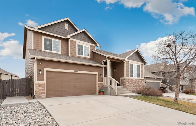 4633 Whirling Oak Way, Colorado Springs, CO 80911 - view of front facade with fence, driveway, an attached garage, and stone siding