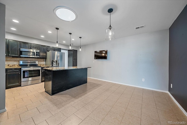 kitchen with light stone countertops, appliances with stainless steel finishes, backsplash, a center island, and hanging light fixtures