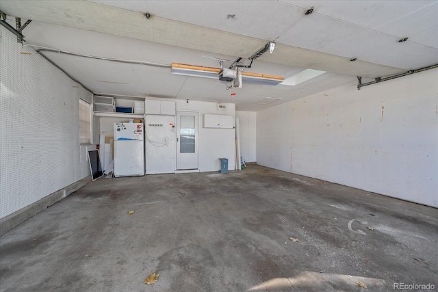 garage with white refrigerator and a garage door opener