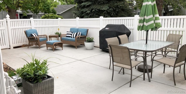 view of patio / terrace with grilling area, a fenced backyard, outdoor dining area, and an outdoor hangout area