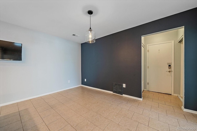 empty room featuring baseboards and visible vents