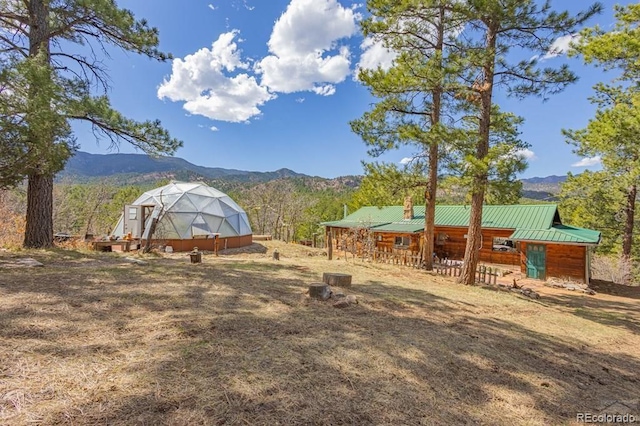 8929 Apache Dr, Beulah, CO 81023 - view of yard featuring a greenhouse, a mountain view, and an outbuilding
