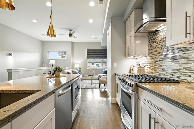 3431 W 16th Ave, Denver, CO 80204 - kitchen with appliances with stainless steel finishes, wall chimney range hood, backsplash, dark wood-type flooring, and stone counters