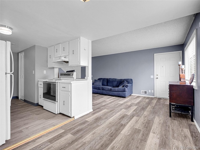 kitchen with white appliances, light wood-type flooring, visible vents, light countertops, and white cabinets