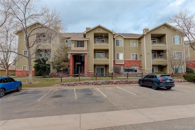 view of property with uncovered parking and fence