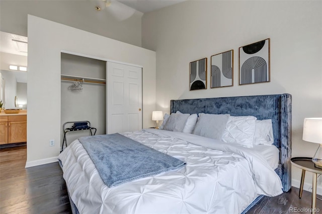 bedroom featuring a closet, dark hardwood / wood-style floors, and ensuite bath