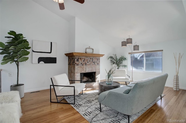 living area featuring visible vents, a fireplace, baseboards, and hardwood / wood-style flooring