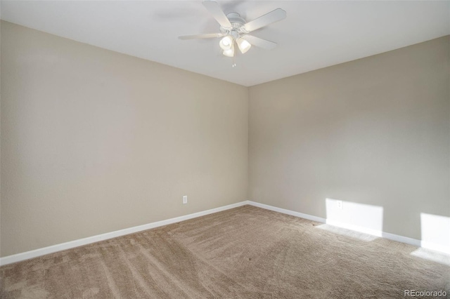 carpeted empty room featuring ceiling fan and baseboards