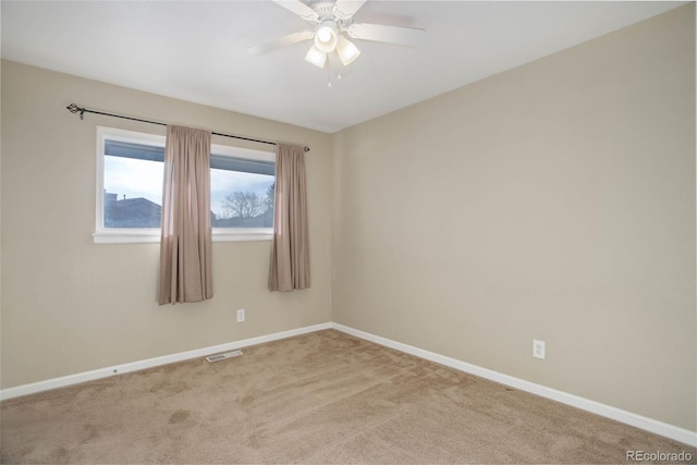 unfurnished room with visible vents, carpet, baseboards, and ceiling fan