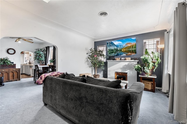 carpeted living room featuring ceiling fan