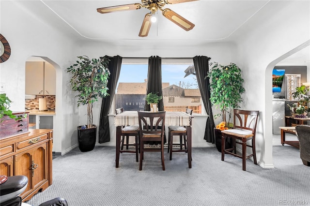 carpeted dining area with ceiling fan