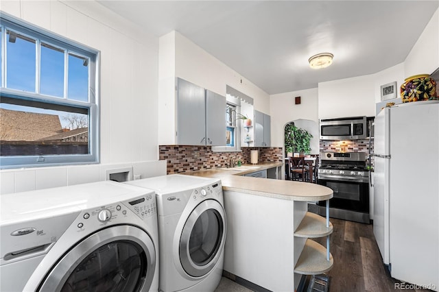 laundry room featuring washer and clothes dryer, sink, and dark wood-type flooring