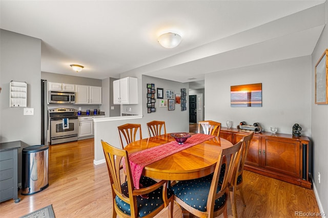 dining space with light hardwood / wood-style floors