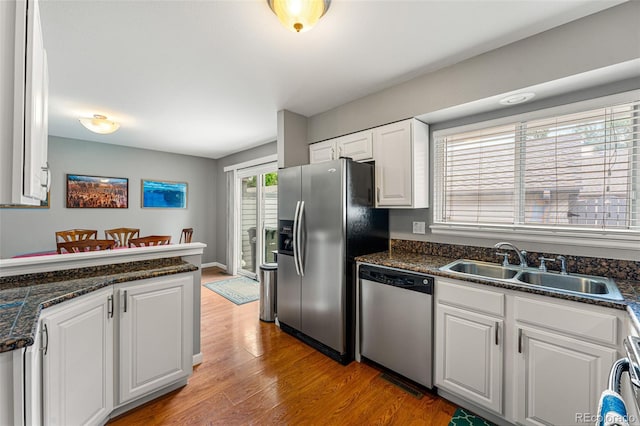 kitchen with sink, white cabinetry, appliances with stainless steel finishes, and light hardwood / wood-style flooring