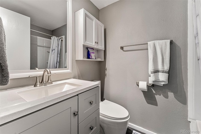 bathroom with toilet, vanity, and walk in shower