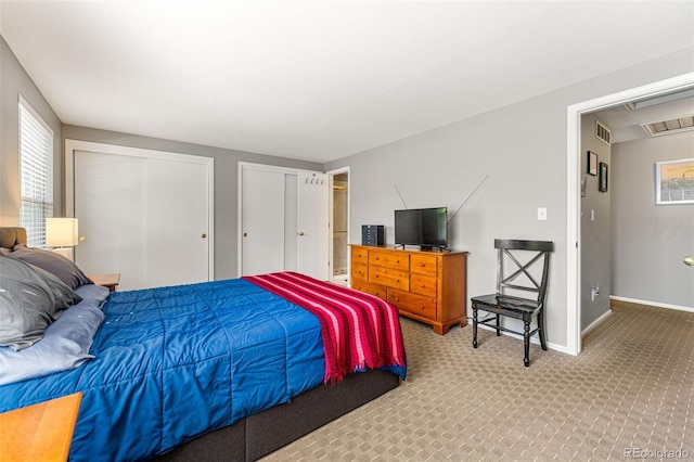carpeted bedroom featuring baseboards, multiple closets, and visible vents
