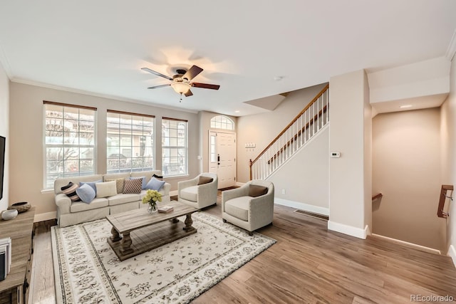 living room featuring light wood-type flooring, ceiling fan, and crown molding