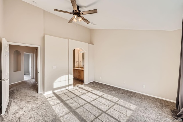 unfurnished bedroom with high vaulted ceiling, ceiling fan, light colored carpet, and connected bathroom