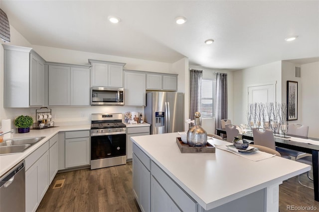 11782 Foraker Ln, Colorado Springs, CO 80925 - kitchen featuring appliances with stainless steel finishes, gray cabinets, a kitchen island, light countertops, and dark wood-style floors
