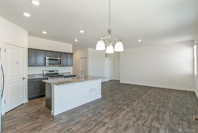 13487 Valentia St, Thornton, CO 80602 - kitchen featuring stainless steel appliances, dark wood-style floors, recessed lighting, a kitchen island with sink, and a sink