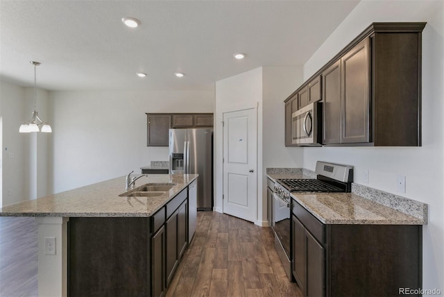 13487 Valentia St, Thornton, CO 80602 - kitchen with stainless steel appliances, a sink, dark brown cabinetry, dark wood-type flooring, and an island with sink