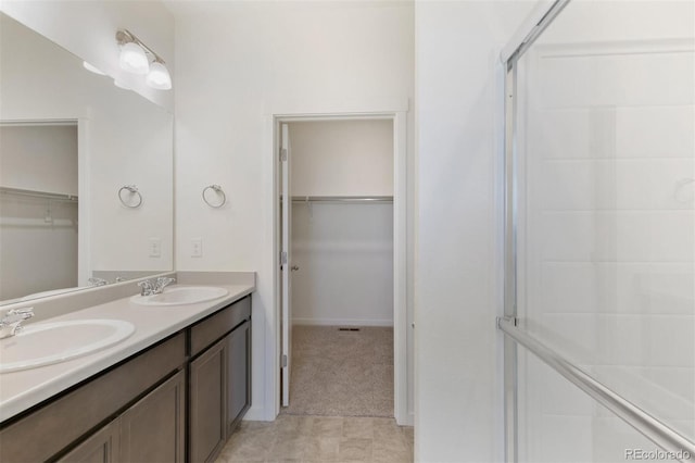 13487 Valentia St, Thornton, CO 80602 - bathroom featuring a walk in closet, double vanity, and a stall shower