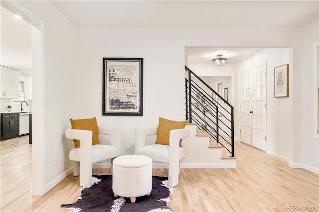 living area with sink and light hardwood / wood-style floors