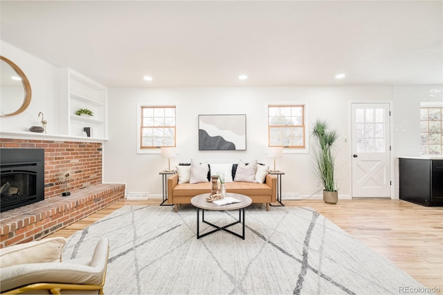 living room with a fireplace and light wood-type flooring