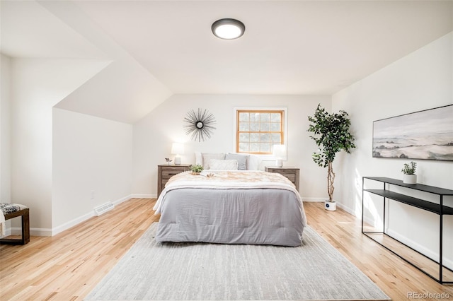 bedroom featuring vaulted ceiling and light hardwood / wood-style floors