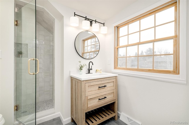 bathroom featuring a shower with door and vanity