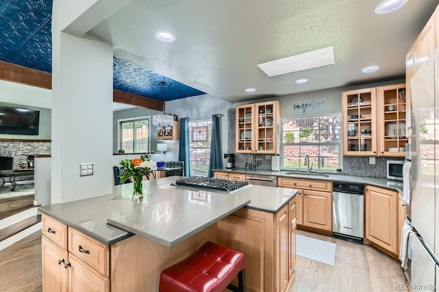 10360 Irving Ct, Westminster, CO 80031 - kitchen featuring light brown cabinetry, appliances with stainless steel finishes, light wood-type flooring, a skylight, and recessed lighting