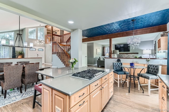 10360 Irving Ct, Westminster, CO 80031 - kitchen featuring stainless steel gas cooktop, a chandelier, light wood finished floors, a kitchen island, and light countertops