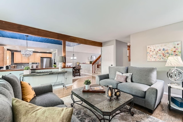 10360 Irving Ct, Westminster, CO 80031 - living area featuring a chandelier, stairway, light wood-style floors, and beam ceiling