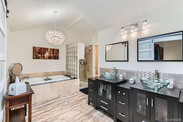 10360 Irving Ct, Westminster, CO 80031 - bathroom with double vanity, a garden tub, wood finished floors, a textured ceiling, and a chandelier