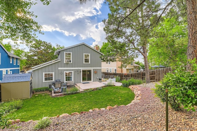 10360 Irving Ct, Westminster, CO 80031 - back of house featuring a patio area, board and batten siding, a shed, and a chimney