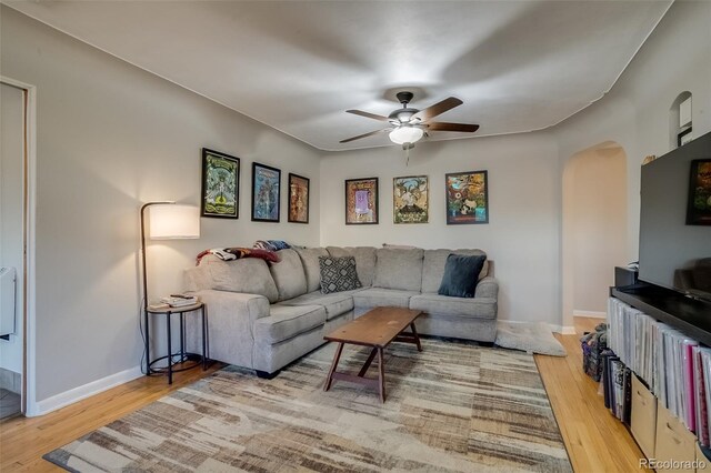 6095 W 47th Ave, Wheat Ridge, CO 80033 - living room with arched walkways, a ceiling fan, light wood-type flooring, and baseboards