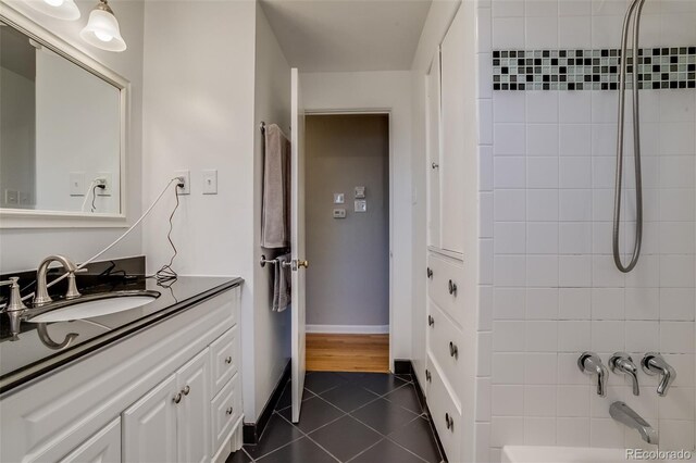 6095 W 47th Ave, Wheat Ridge, CO 80033 - bathroom featuring tile patterned floors, vanity, bathtub / shower combination, and baseboards