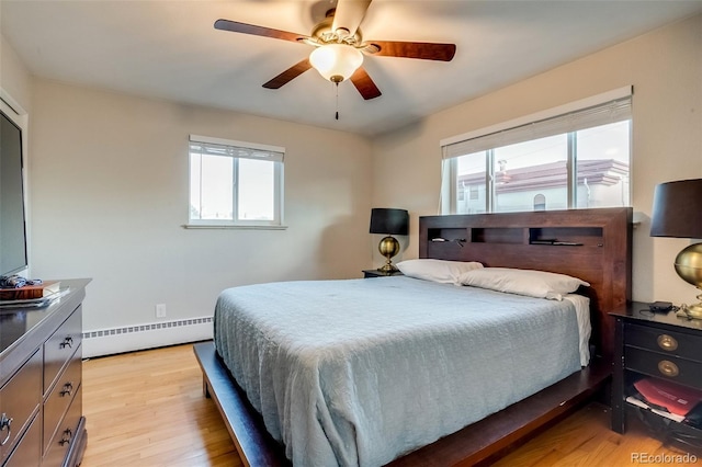 6095 W 47th Ave, Wheat Ridge, CO 80033 - bedroom with a baseboard heating unit, multiple windows, light wood-type flooring, and ceiling fan