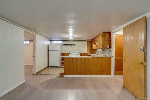 6095 W 47th Ave, Wheat Ridge, CO 80033 - kitchen with white appliances, light wood-type flooring, a peninsula, light countertops, and brown cabinetry