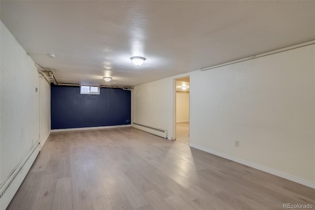 6095 W 47th Ave, Wheat Ridge, CO 80033 - basement featuring a baseboard heating unit, wood finished floors, and baseboards