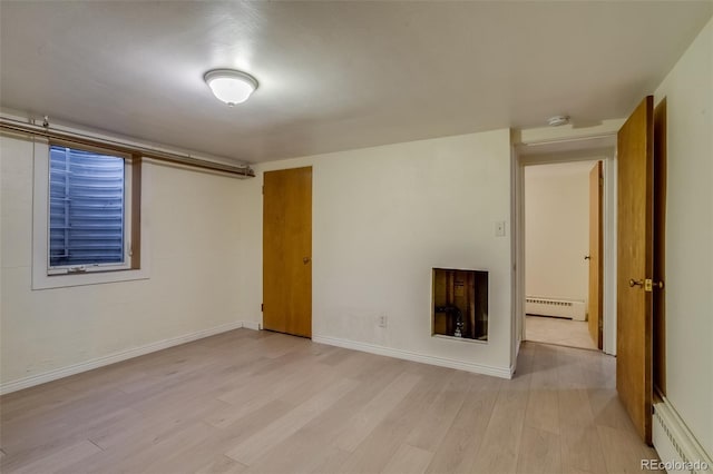 6095 W 47th Ave, Wheat Ridge, CO 80033 - unfurnished room with a baseboard heating unit, light wood-style flooring, baseboards, and a smoke detector
