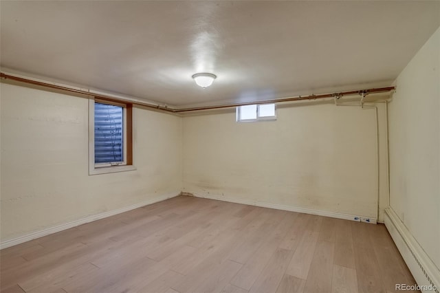 6095 W 47th Ave, Wheat Ridge, CO 80033 - below grade area with a baseboard radiator, light wood-style flooring, and baseboards